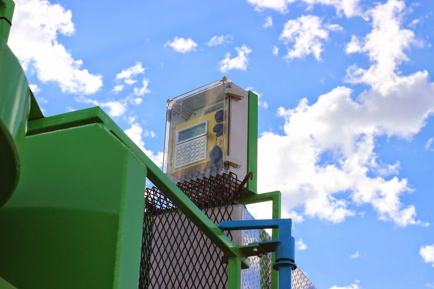 Rapidlogger recorder in a clear enclosure on an acid pumping unit, seen from below against the sky